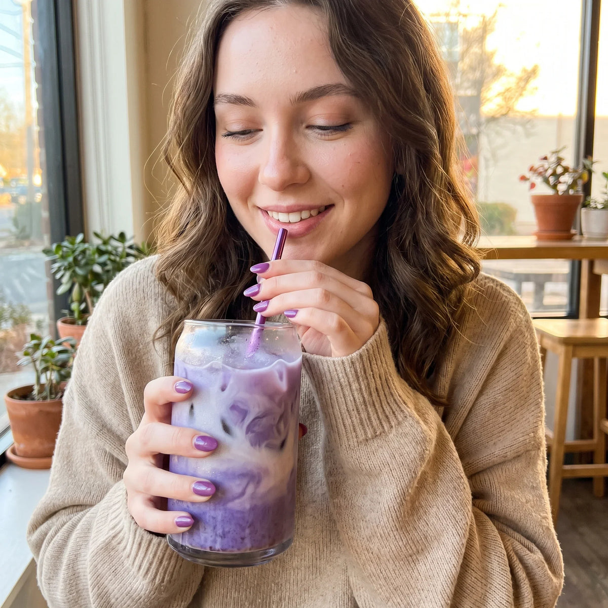 Woman drinking an iced ube latte made with ube powder