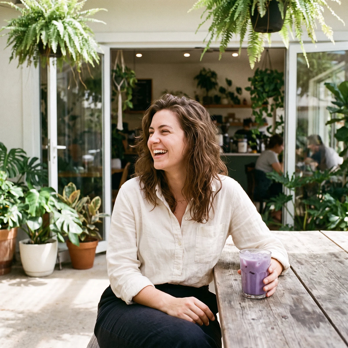 Woman enjoying a purple ube drink at a café terrace